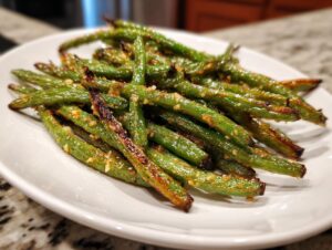 Close-up of perfectly roasted green beans seasoned with garlic and spices, ready to serve.