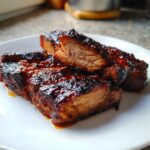 Close-up of three thick, juicy pieces of glazed pork steak recipe, showing a caramelized dark exterior and tender interior.