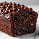 Close-up of a rich, dark chocolate banana bread loaf topped generously with melted chocolate chips.