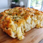 Close-up of cheesy pull-apart cheese bread showing long, stretchy strings of melted cheese.