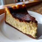 A close-up slice of creamy Basque cheesecake featuring a deeply caramelized, almost burnt top layer.