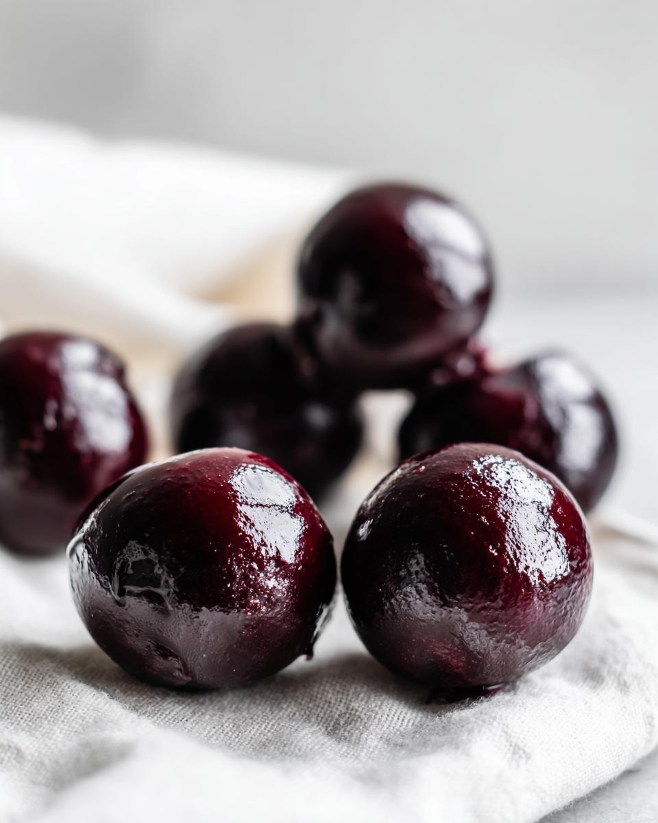 Close-up of dark, glossy, marinated cherries ready for making chocolate covered cherries.
