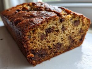 Close-up of a moist, freshly baked chocolate chip banana bread loaf showing the rich crumb texture.