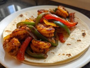 Close-up of seasoned shrimp fajitas with red and green bell peppers served on a warm flour tortilla.