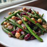 Close-up of a vibrant green bean salad featuring chickpeas, red onion, and dark red kidney beans, perfect for a zesty bean salad.