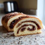 Close-up of a sliced italian nut roll cookies showing the swirl of sweet nut filling inside the soft dough.