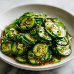 Close-up of thinly sliced cucumbers marinated in a savory dressing for an amazing asian cucumber salad.
