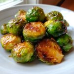 Close-up of roasted Orange Maple Glazed Brussels Sprouts coated in a shiny, caramelized glaze.