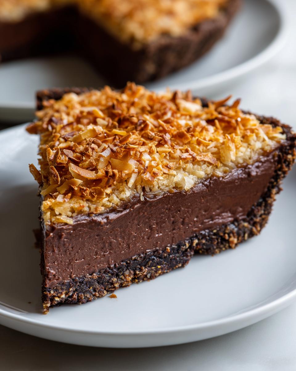 A close-up slice of decadent german chocolate pie featuring a dark chocolate filling and a thick layer of toasted coconut topping.