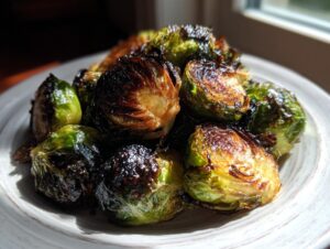 Close-up of roasted Brussels sprouts coated in a shiny Sticky Brussels Sprouts Glaze, showing caramelized edges.